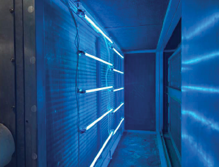 Blue UVC light illuminating the interior of an HVAC air handling unit